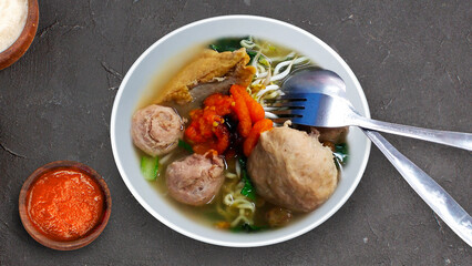 bakso noodle meatball indonesian food with noodles, tofu, chili sauce, sweet soy sauce and sprinkle green onion