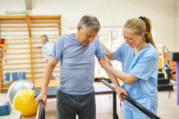 Physiotherapist assisting elderly man in movement therapy