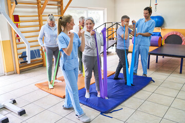 Therapists with group of elderly patients at rehabilitation center