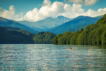 Tourists enjoying kayaking on lake Vidraru on Arges , Romania