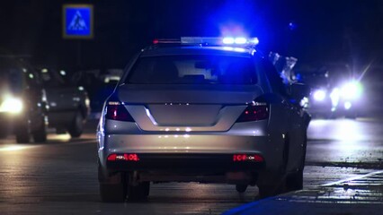 Lightbar flasher blinking blue light atop police car at night, siren. Emergency vehicle lighting on highway patrol auto during traffic collision accident or crime scene. Roads traffic authority. 911