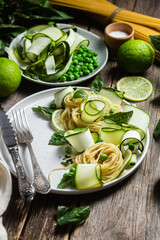 Pasta with zucchini and green peas in a bowl