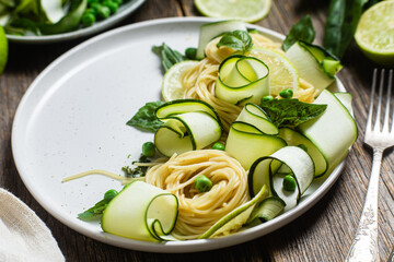 Pasta with zucchini and green peas in a bowl