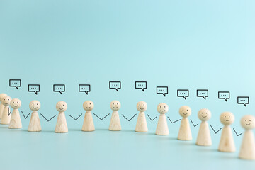 Wooden figures with speech bubbles. Concept of communication, information, and cooperation