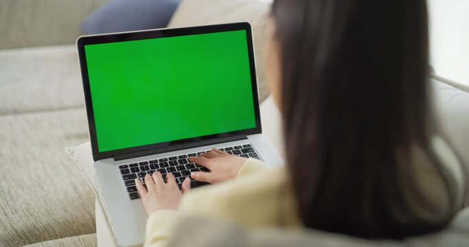 녹색 목업 화면이 떠 있는 노트북으로 일하는 여성을 어깨 너머로 본 영상