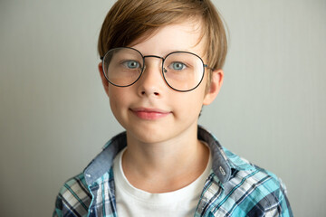 Teenage boy smiling looking at camera with glasses over white background, portrait
