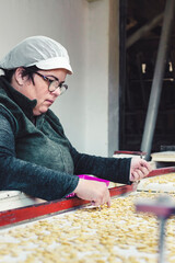 Working woman selecting beans in production line