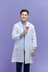 doctor holding red heart shape agains purple background