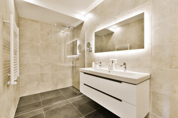 a modern bathroom with black and white floor tiles on the walls, sink, mirror and shower stall in the corner