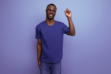 handsome young american man in blue t-shirt shows his hand towards space