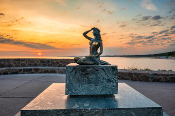 Mermaid statue by the Baltic Seain Ustka at sunrise. Poland