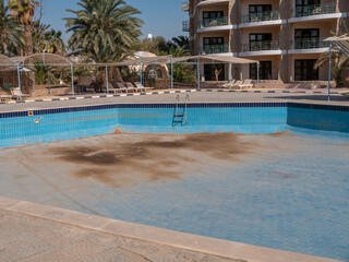 Abandoned old hotel, empty pool without water.