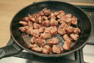 Woman mixing the meat in a frying pan shovel. Pan-fried meat, French fries