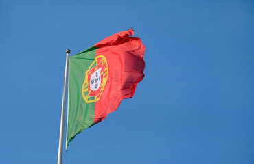 Portuguese flag waving in the wind against a clear sky
