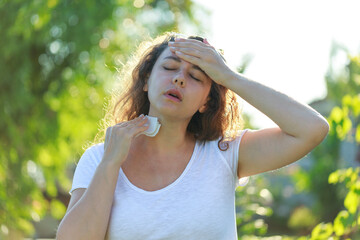 Young woman having hot flash and sweating in a warm summer day