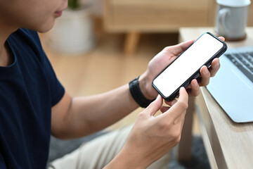 Close up with Young Asian man using a smartphone, Empty screen of the phone for banner or advertisement.