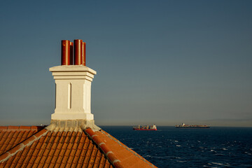 Latarnia morska Europa Point. Komin budynku latarni w tle kontenerowiec morski. 