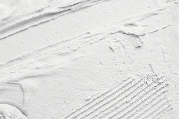 Decorative white putty background. Wall texture with filler paste applied with spatula, chaotic...