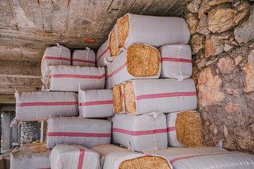 organized stacks of packed hay in a barn, carefully prepared to provide feed for livestock.