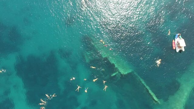Drone footage of people swimming next to a sunken ship  in Elba Island, Tuscany, Italy