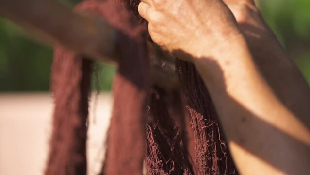 Women drying natural silk or cotton threads dyed in a rural way of life.