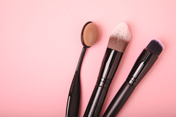 Cosmetic makeup brush on a pink background. Cosmetic product for make-up. Creative and beauty fashion concept. Fashion. Collection of cosmetic makeup brushes, top view, banner.Place for text. MOCAP. - obrazy, fototapety, plakaty