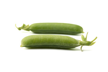 Soft focus on ripe closed pea pods on white background. Focus on the front pod.