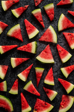 Watermelon slices on dark surface.