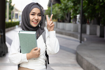Young Muslim Woman Student pointing up V for victory 2 fingers, Back to School. Education...