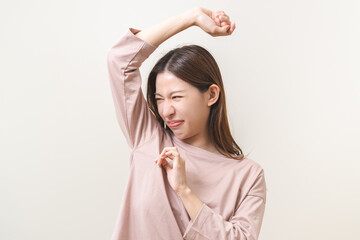Bad smelling, deodorant asian young woman smell stink, breathing nose on armpit with underarm,...