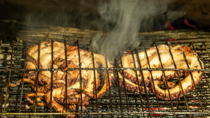 Octopuses fresh out of the Aegean Sea are cooked on the grill fire. Gokceada, Gokceada, Canakkale, Turkey