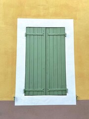 Green window shutters and yellow wall