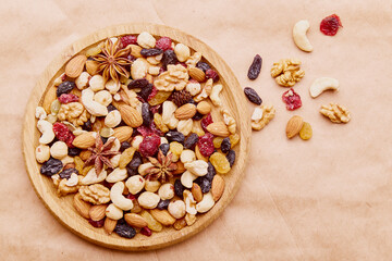 Assorted nuts and raisins in wooden tray on natural rustic background