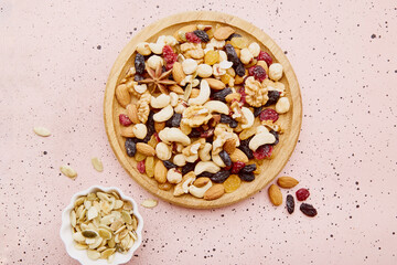 Assortment of nuts and raisins in wooden tray flat lay. Healthy eating, dessert