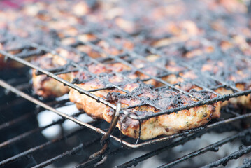 the grilled meat on the metal grid is slightly burnt