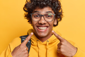 People positive emotions concept. Studio close up of young happy Hindu male student wearing yellow...