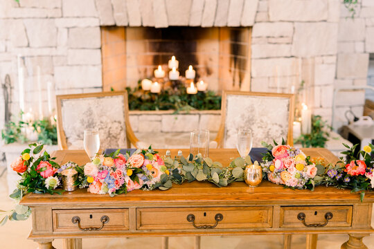 Table with floral arrangement and two framed photos of deceased relatives.