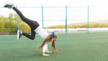 One active young girl, fit sporty child climbing, outdoor exercise, hanging on a bar on a playground, portrait, closeup. Children and healthy physical activities in summer simple concept, lifestyle