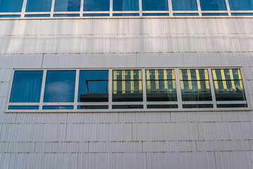 Fototapeta na wymiar Reflections in a modern glass building, 20th arrondissement, Paris, France
