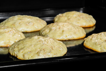 Close up view: process of cooking many homemade crunchy oatmeal cookies on metal sheet in oven. Dessert, cookery, baking, gastronomy concept