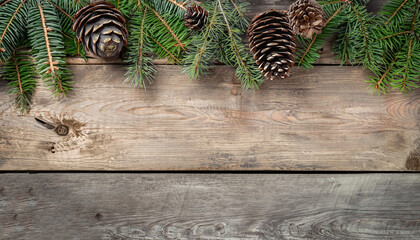 Christmas composition. Frame made of pine branches, fir cones on rustic vintage wooden background. Flat lay, top view, copy space.