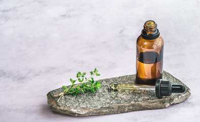 gesund Aromatherapie mit Gewürz Öl, Thymian, Thymianöl. Eine Ölflasche steht auf einem Stein,...