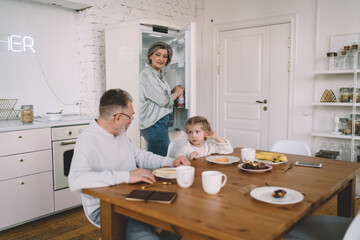 Obraz premium Grandfather talking to granddaughter while having lunch