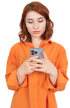 Woman using smartphone, close up portrait of  young attractive cheerful red hair woman using smartphone. Wear orange shirt, standing isolated transparent png image. Serious face expression. 