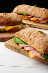 Chiabatta sandwich with ham and cheese on wooden board