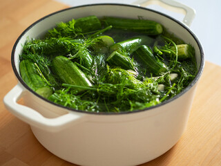 Preservations, conservation. Salted, pickled cucumbers in a pan on wooden table.