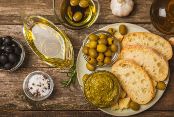 Bruschetta with olive oil, olives, pesto, garlic and parmesan. ciabatta bread with olive oil and...