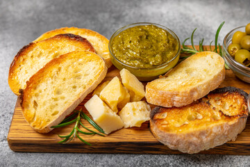 Bruschetta with olive oil, olives, pesto, garlic and parmesan. ciabatta bread with olive oil and...