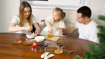 A little girl enjoys some honey from a jar