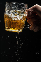 glass of splashing beer. Freeze motion splash drops of beer foam
